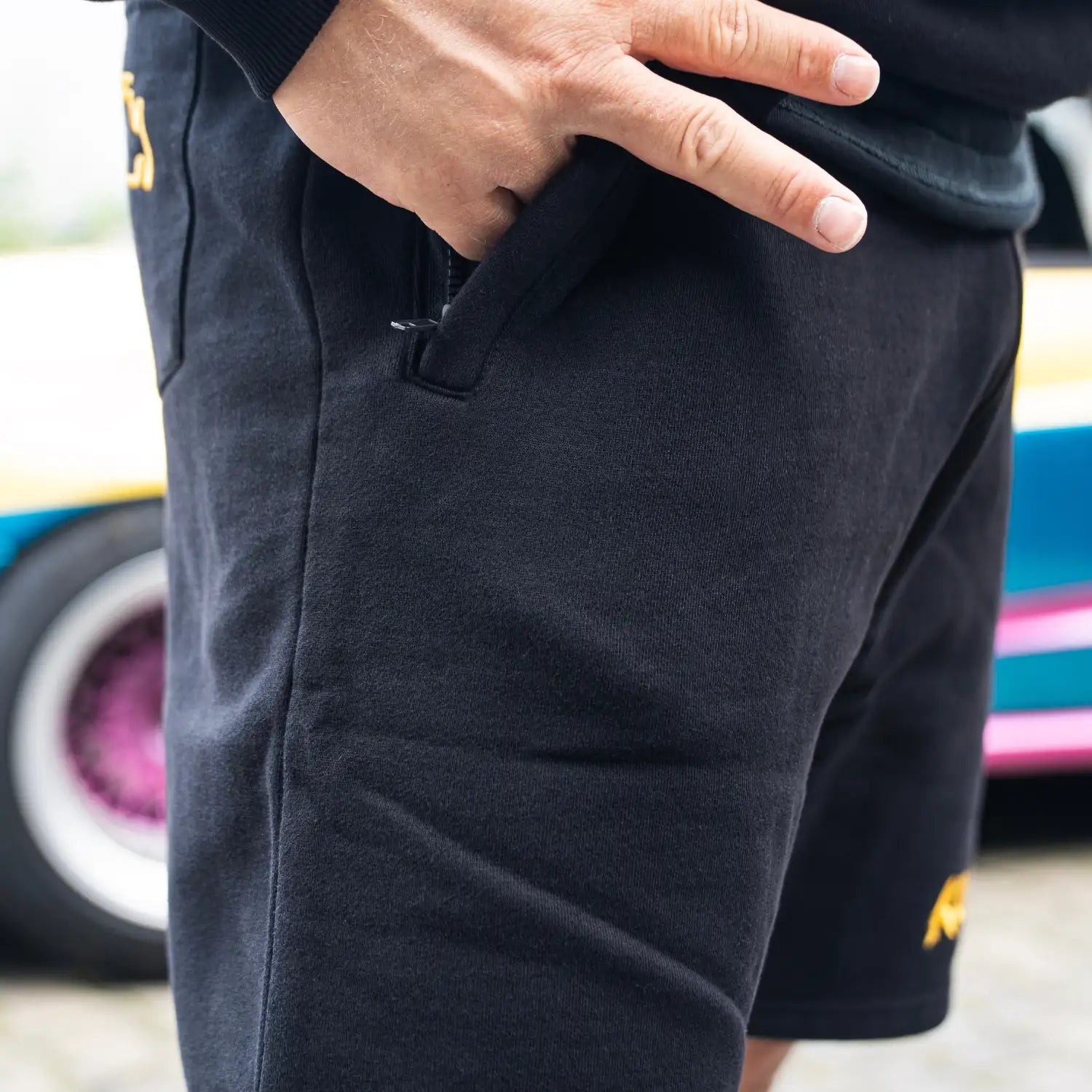 Seitentasche der schwarzen „KUNDE!“ Shorts mit Hand in Tasche zur Darstellung der Funktion.