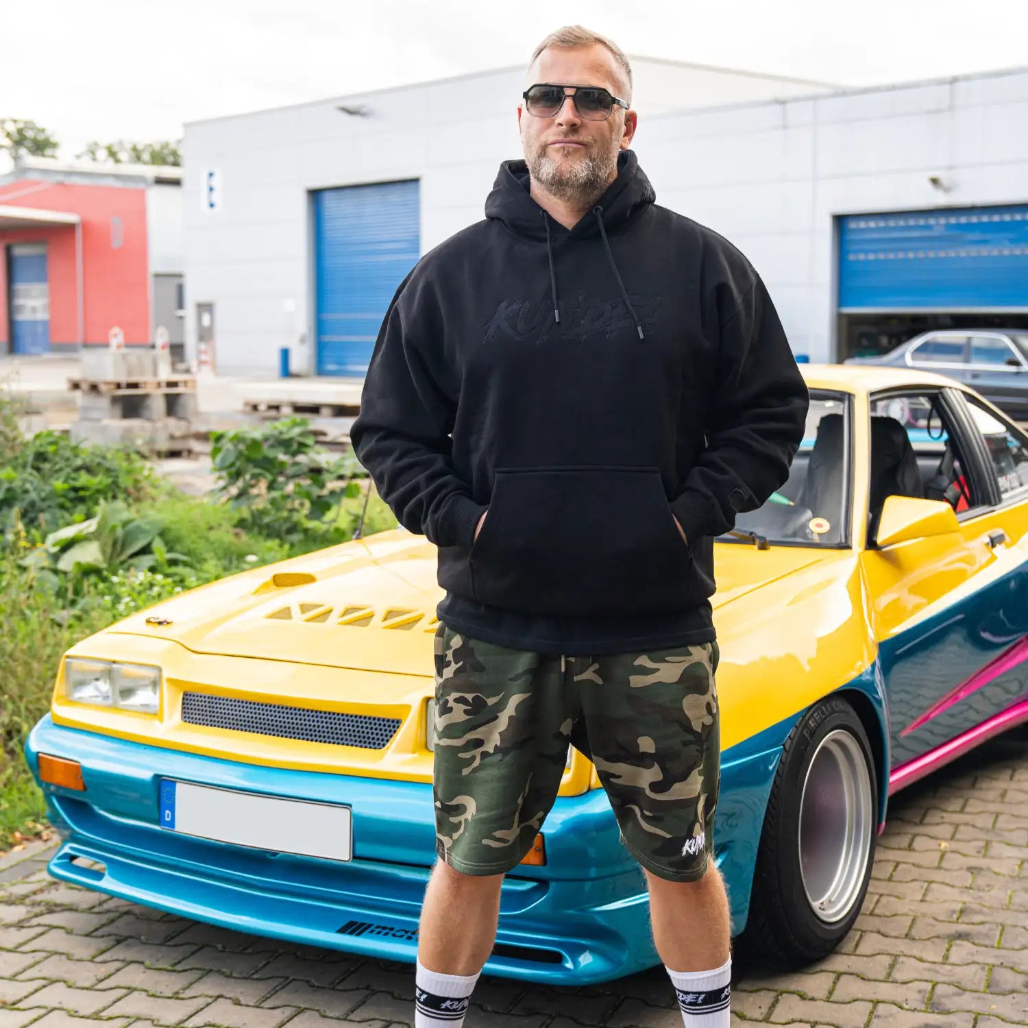 Kunde Hoodie in Schwarz/Anthrazit am Model getragen. Oversized Schnitt. Modell ist 1,84 m groß und trägt Größe L.