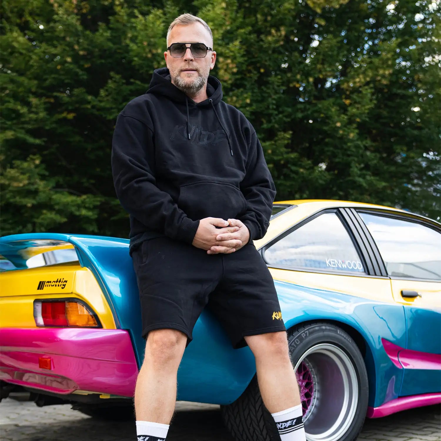 Schwarze „KUNDE!“ Shorts in Alltagsszene, getragen im entspannten Freizeitlook.